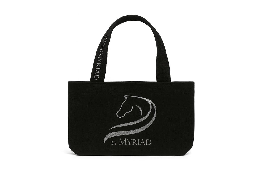 Black canvas tote bag with the by Myriad logo in reflective silver