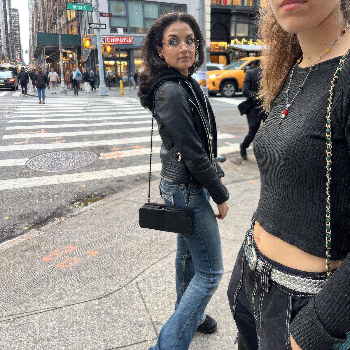 Woman wearing the Hestia black pebble mini crossbody bag on a New York City street