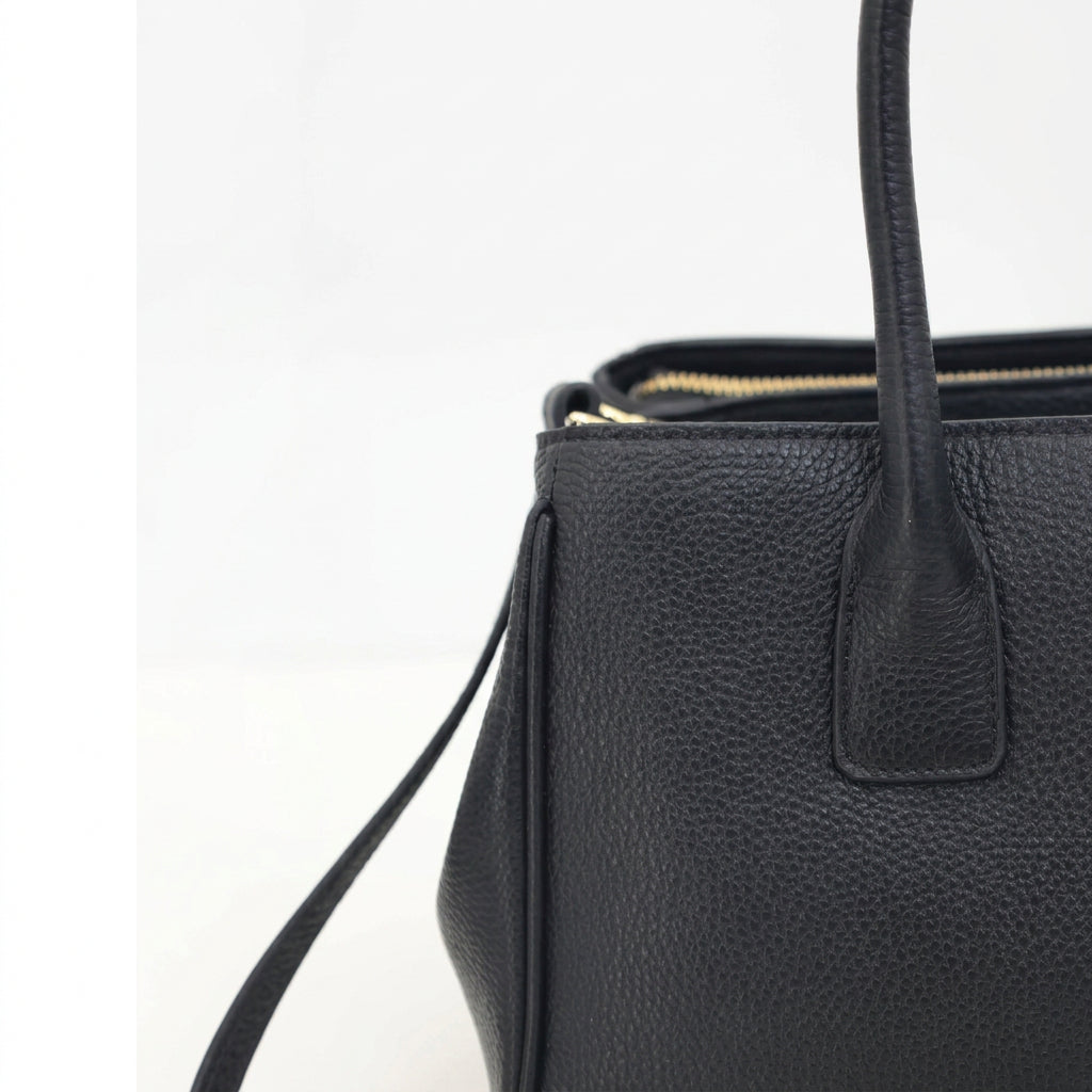 Close-up of the Roma black pebbled leather tote's top handle and pebble grain