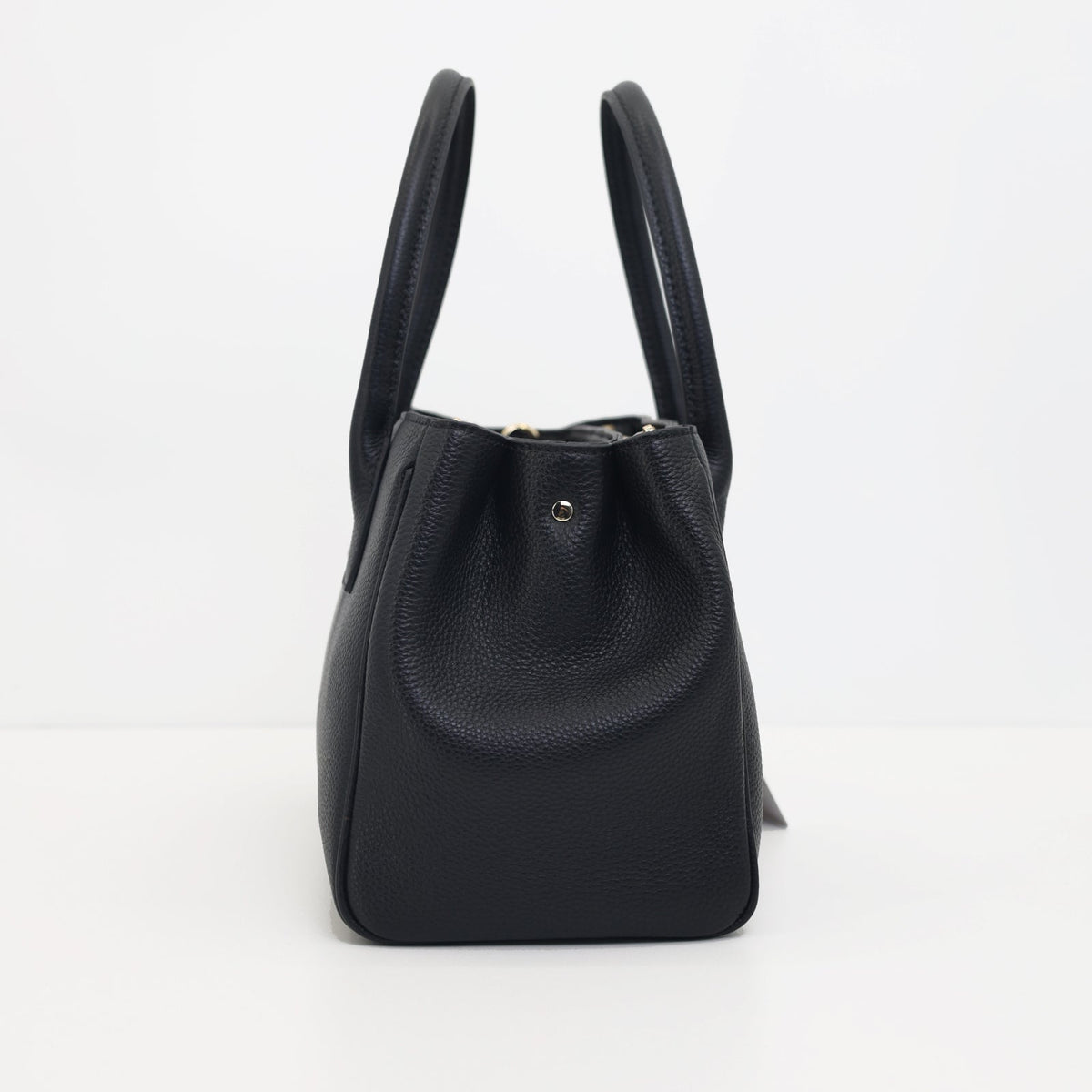Side view of the Roma black pebbled leather tote with its two top handles standing