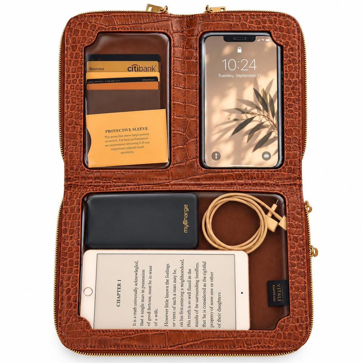 Vallina cognac crossbody open flat with a phone in the touchscreen pocket, cards, tablet and cable organized inside